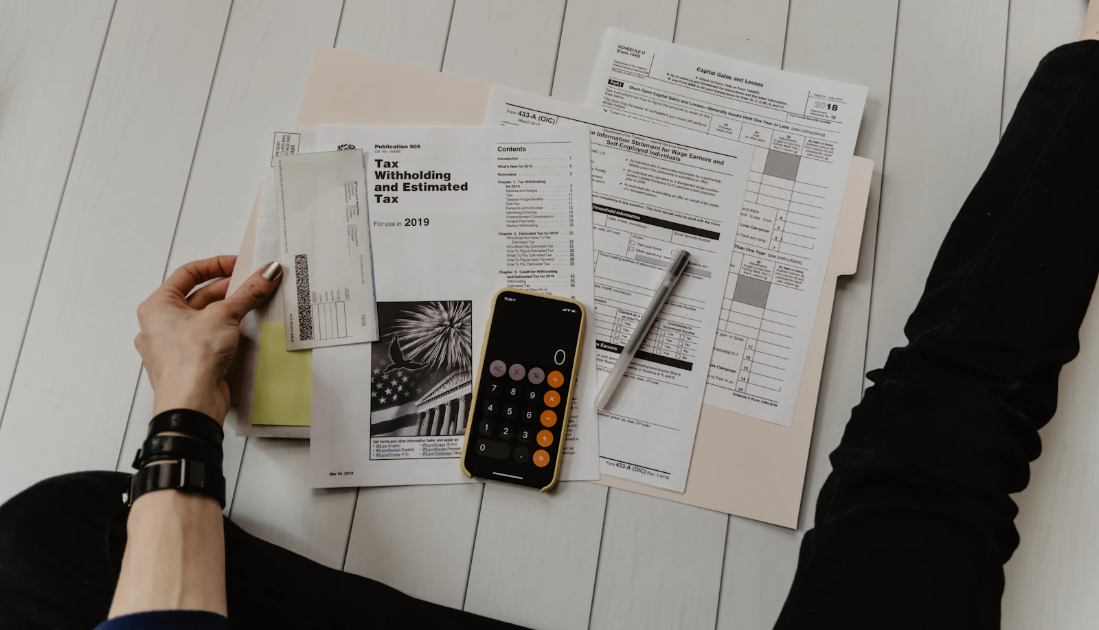 Accounting paperwork, a calculator and a notebook on a desk