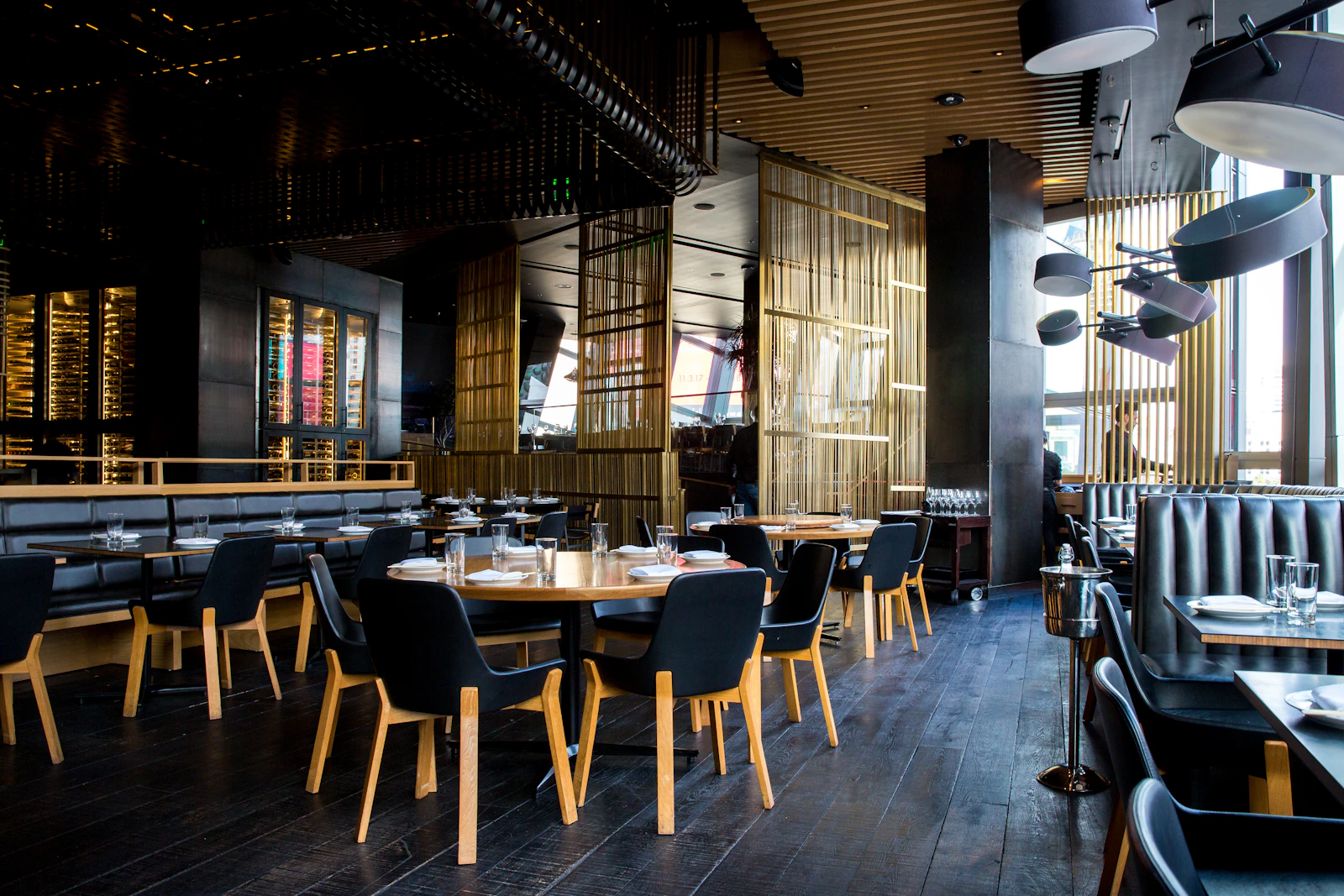 A contemporary dining room with timber tables and warm pendant lighting