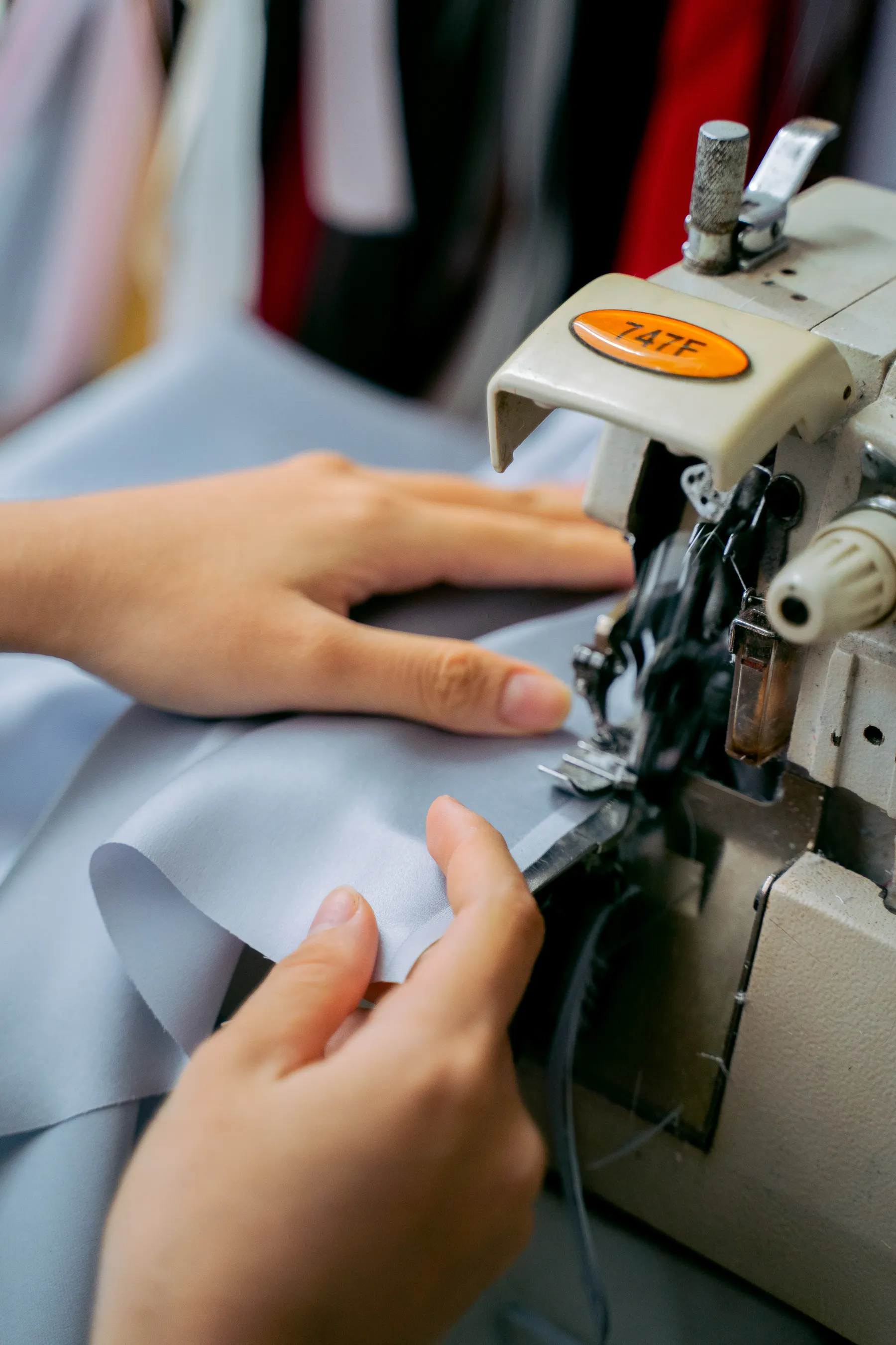 Hands guiding fabric through a sewing machine