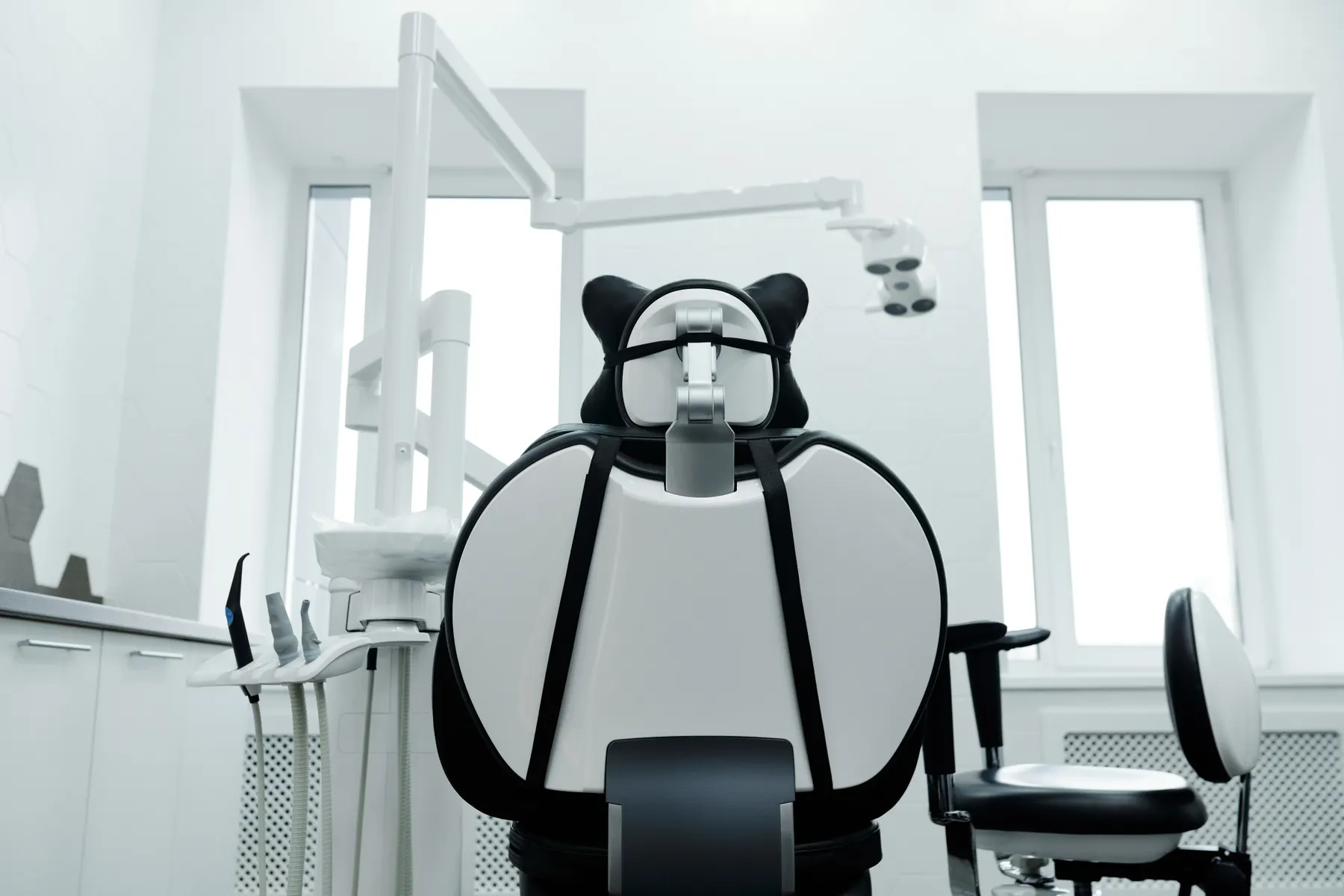 Bright dental treatment room with a chair and overhead equipment
