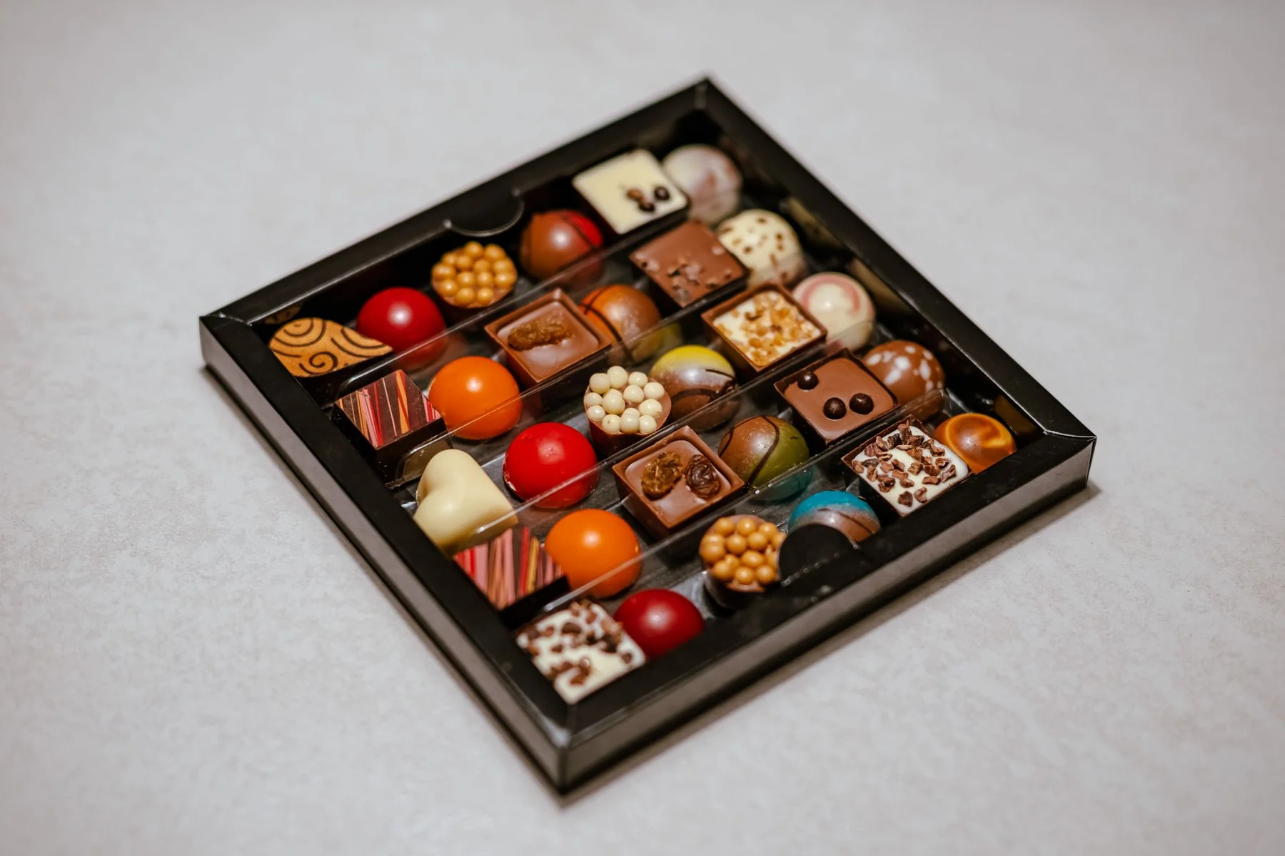 Colorful chocolate pralines in a black box
