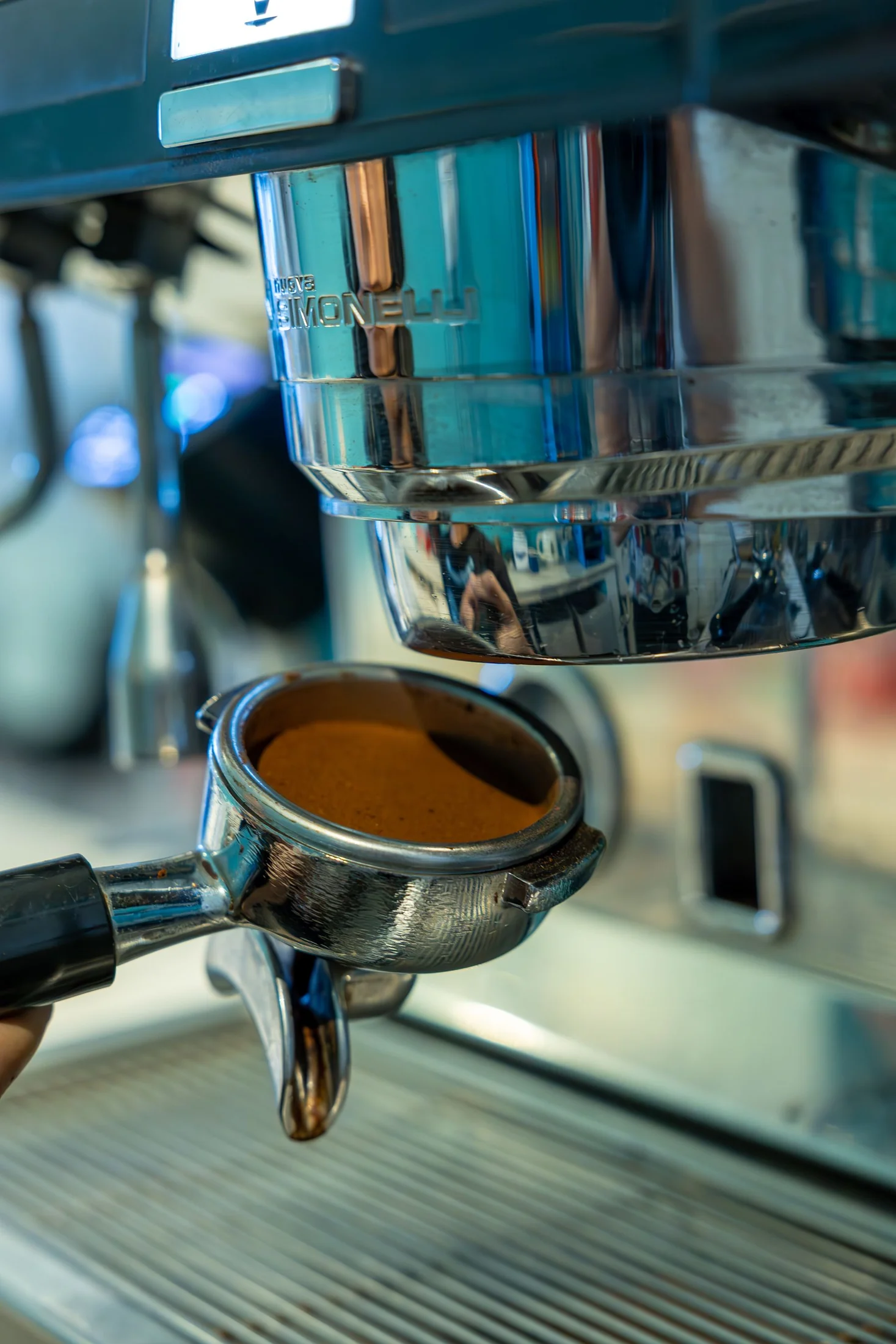 A portafilter beneath a coffee grinder