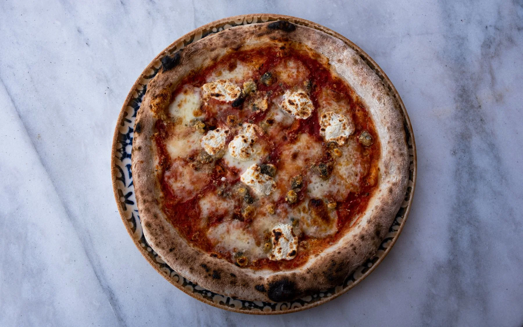 Tomato and cheese pizza on a marble table
