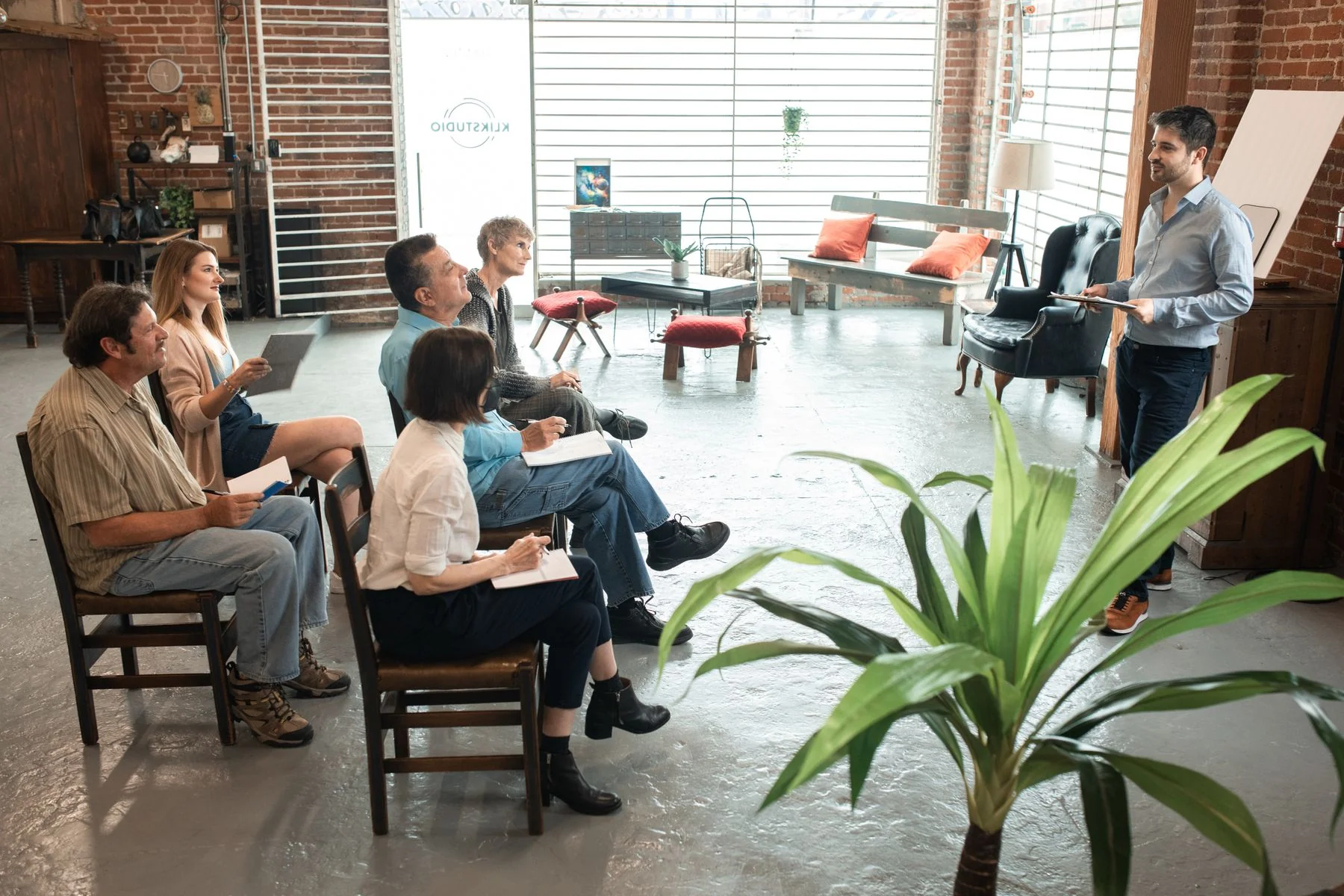 A small group attending a workshop in a brick-walled room