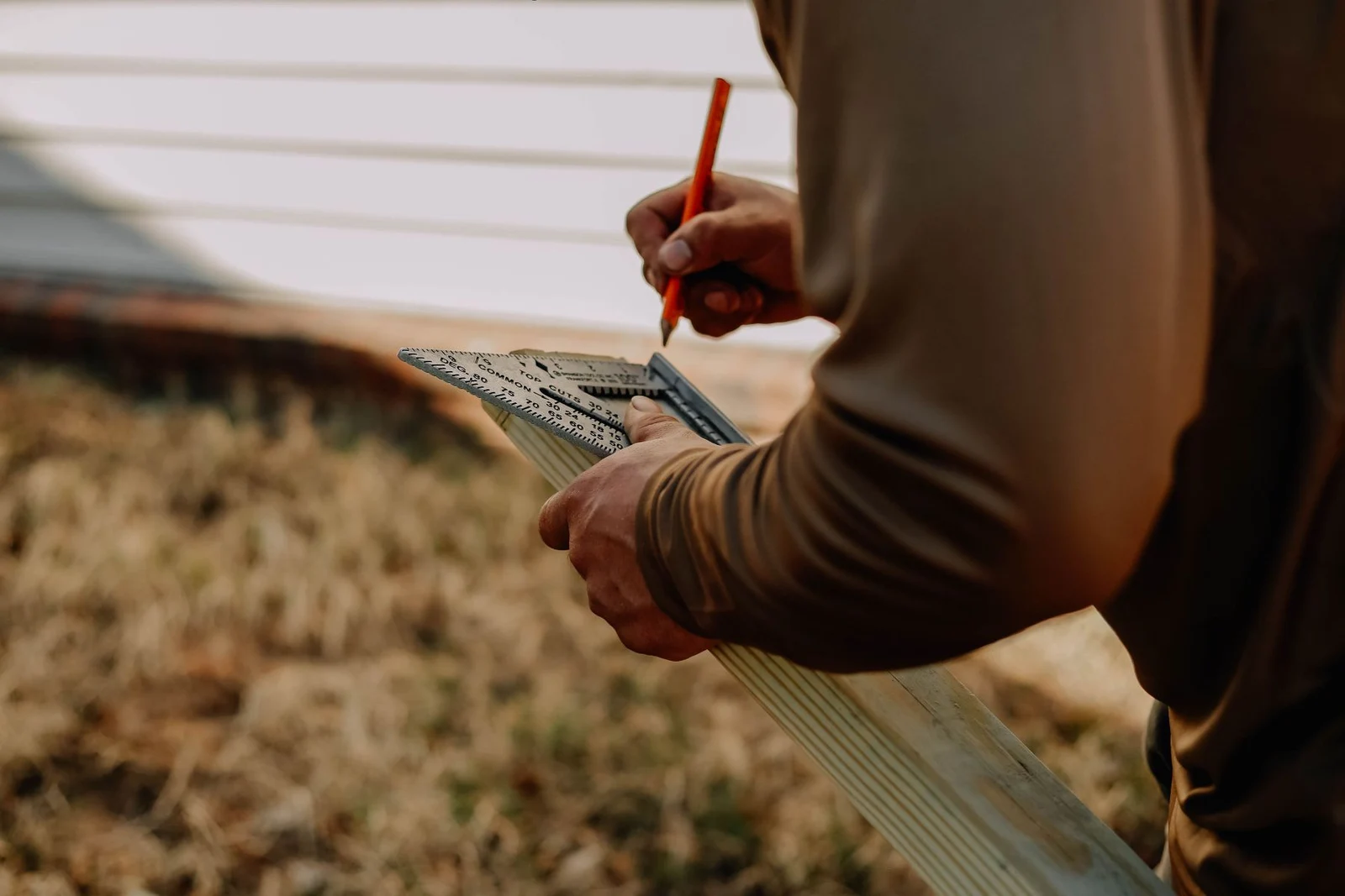 Carpenter measuring timber with a square
