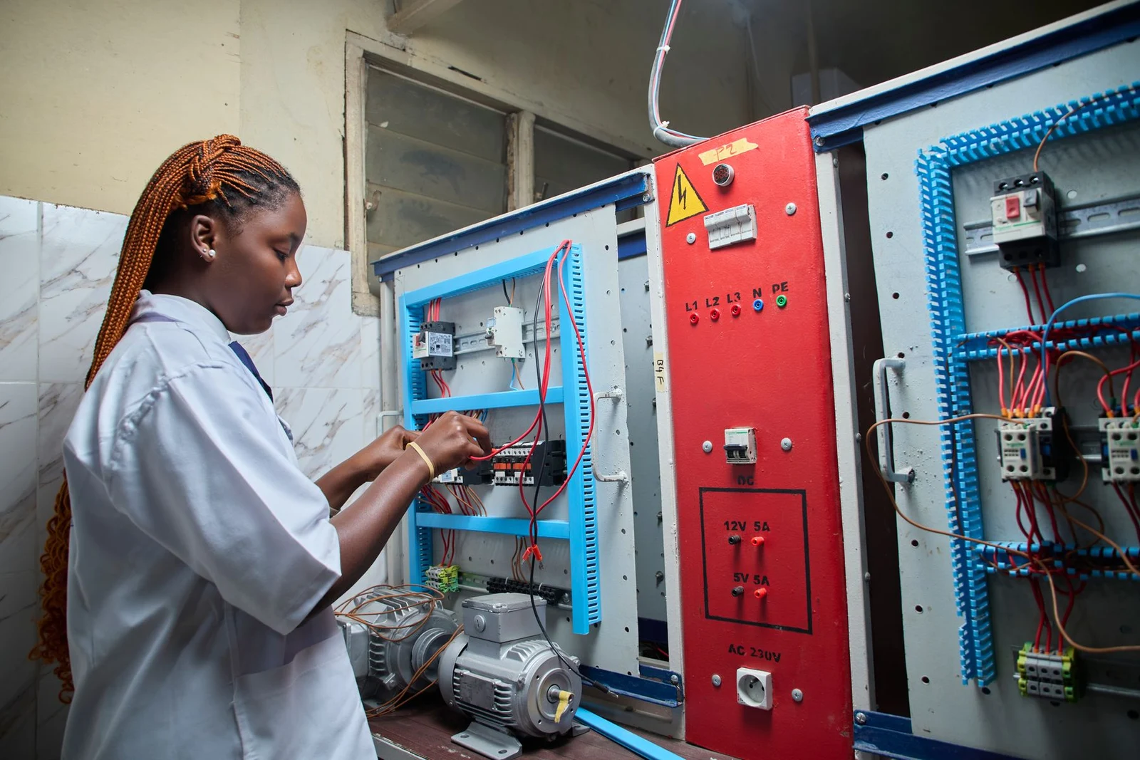 Technician working with an electrical training and control panel