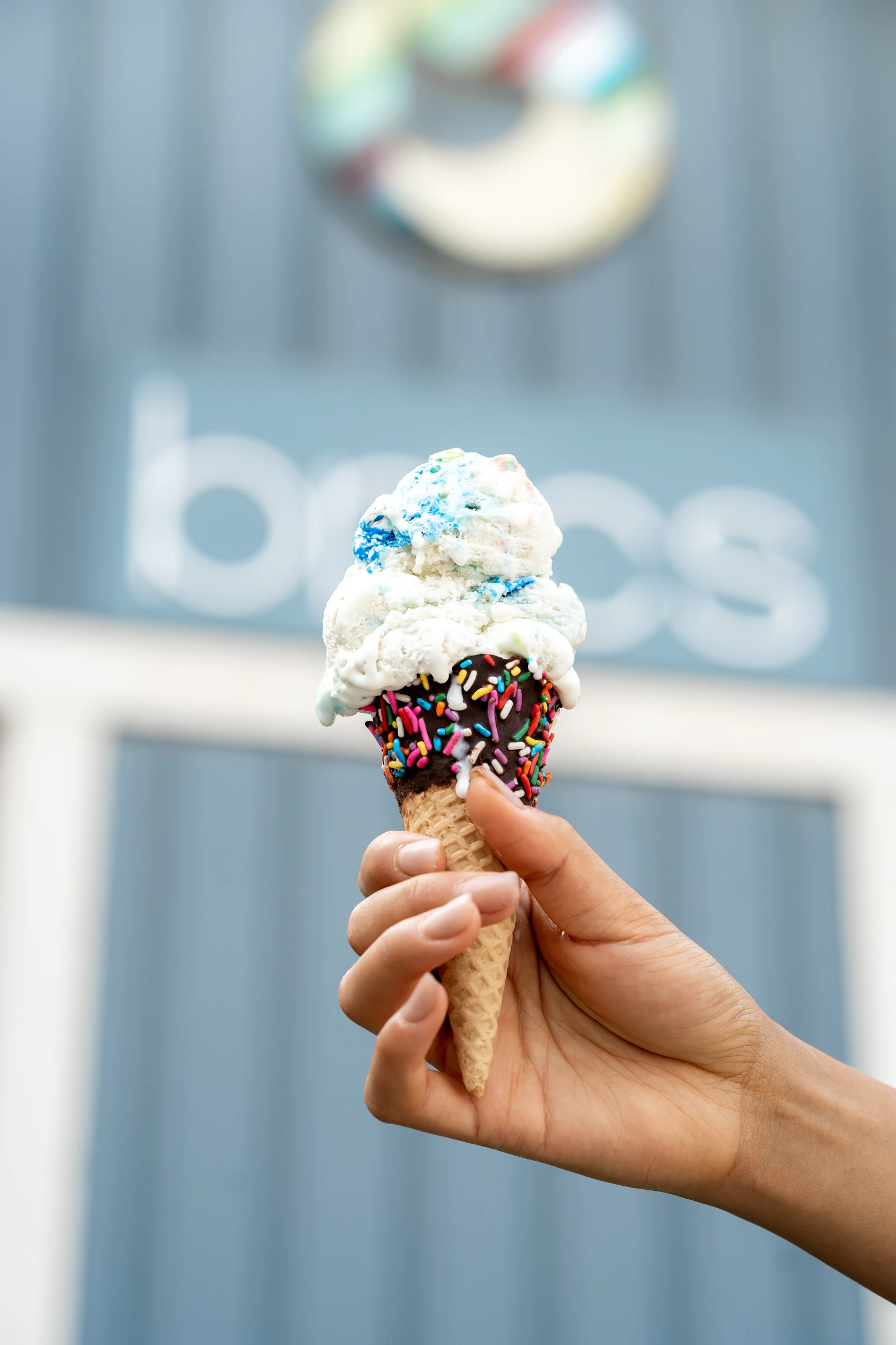 Two scoops of ice cream in a sprinkle-covered cone