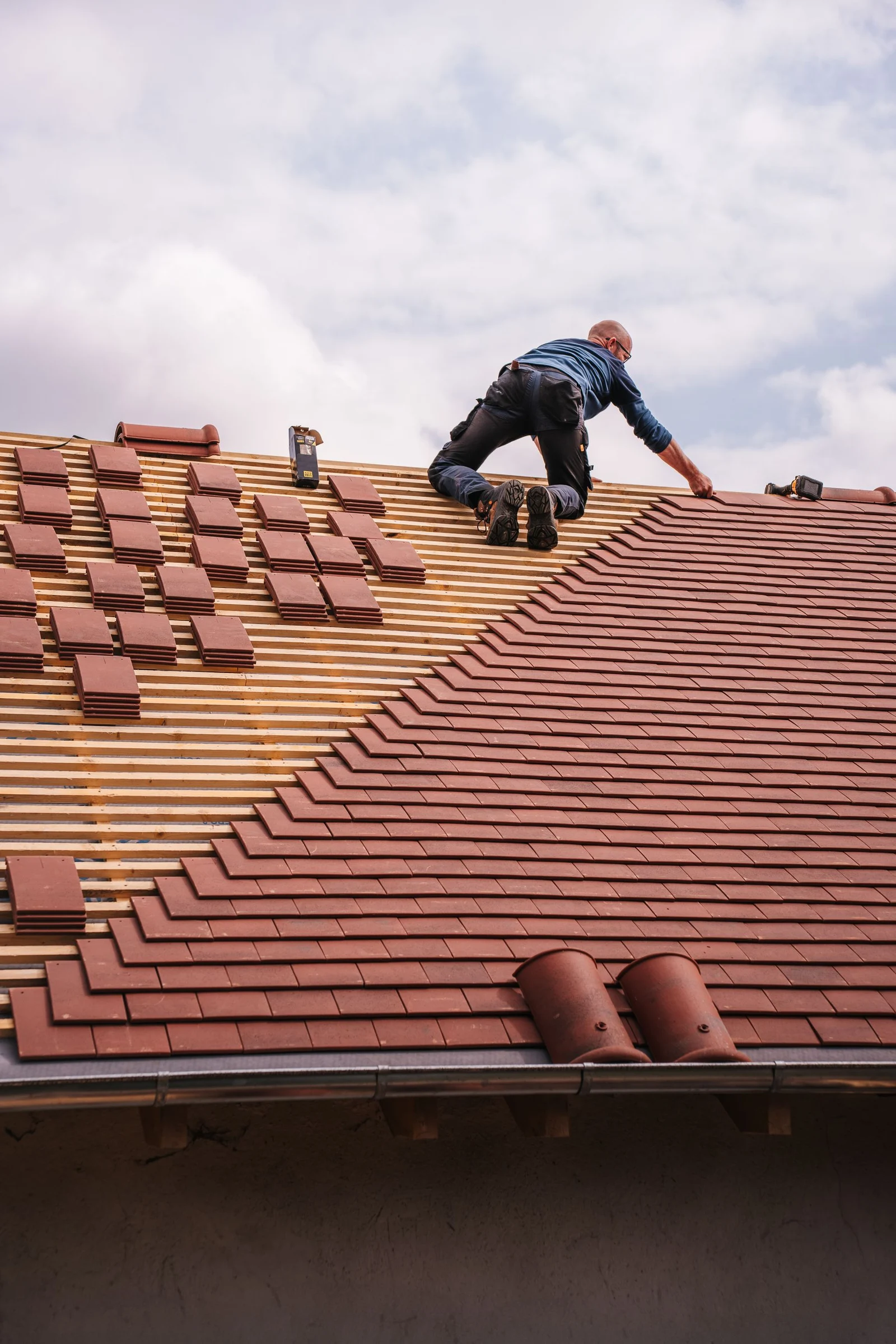 Worker attending to a red tiled roof